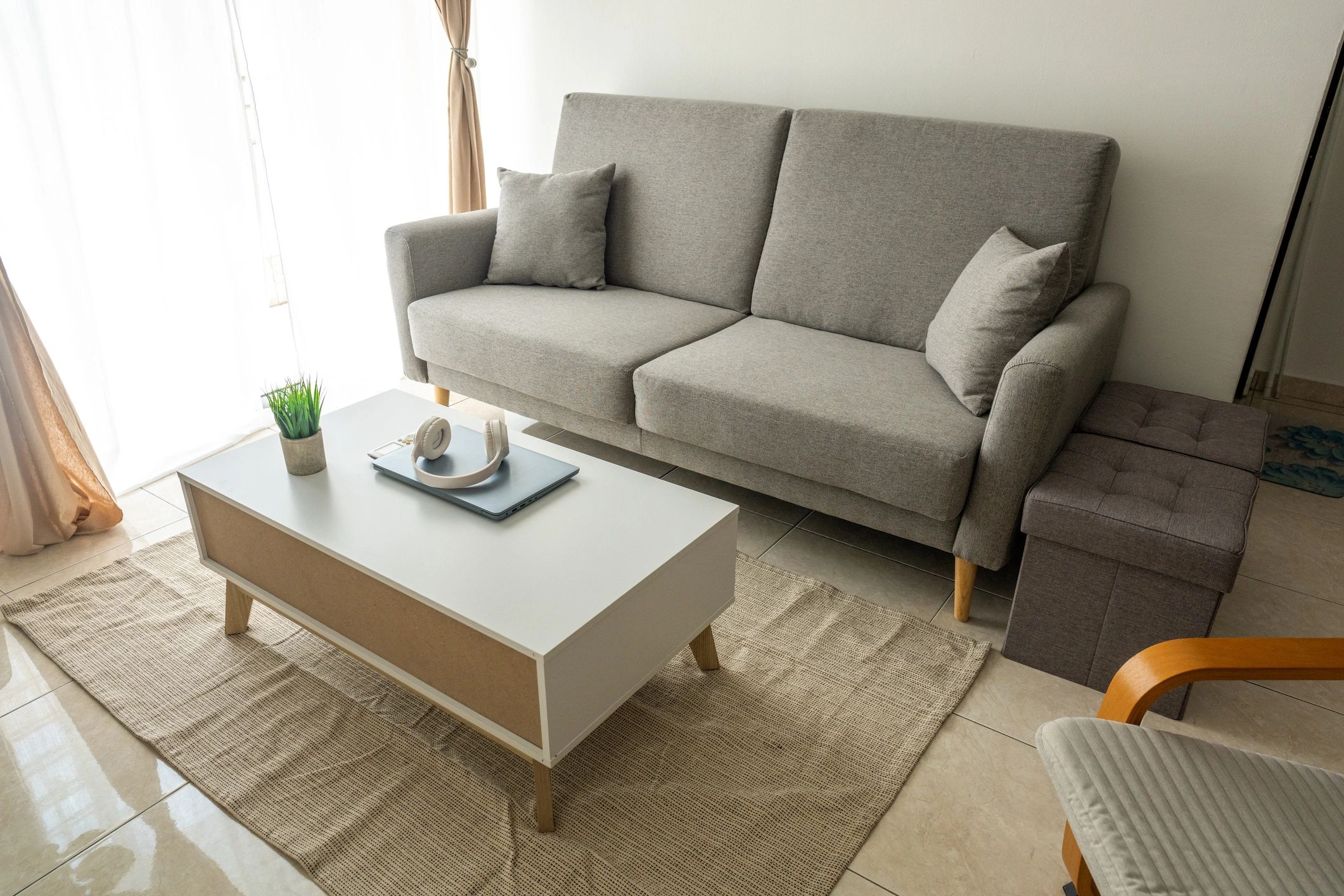 Simple modern living room with grey sofa and ceramic tile flooring